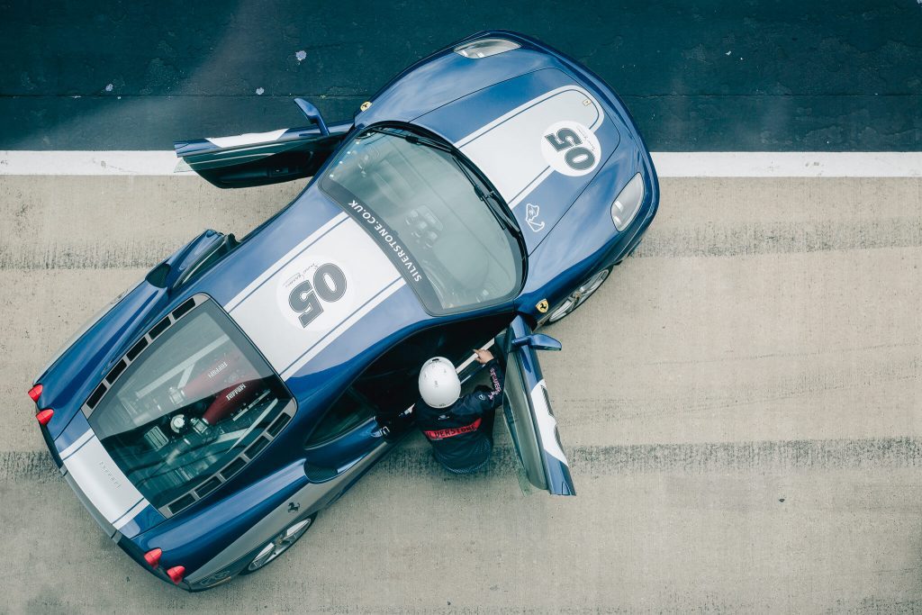 Driver getting into Ferrari in pit lane from overhead - Silverstone circuit