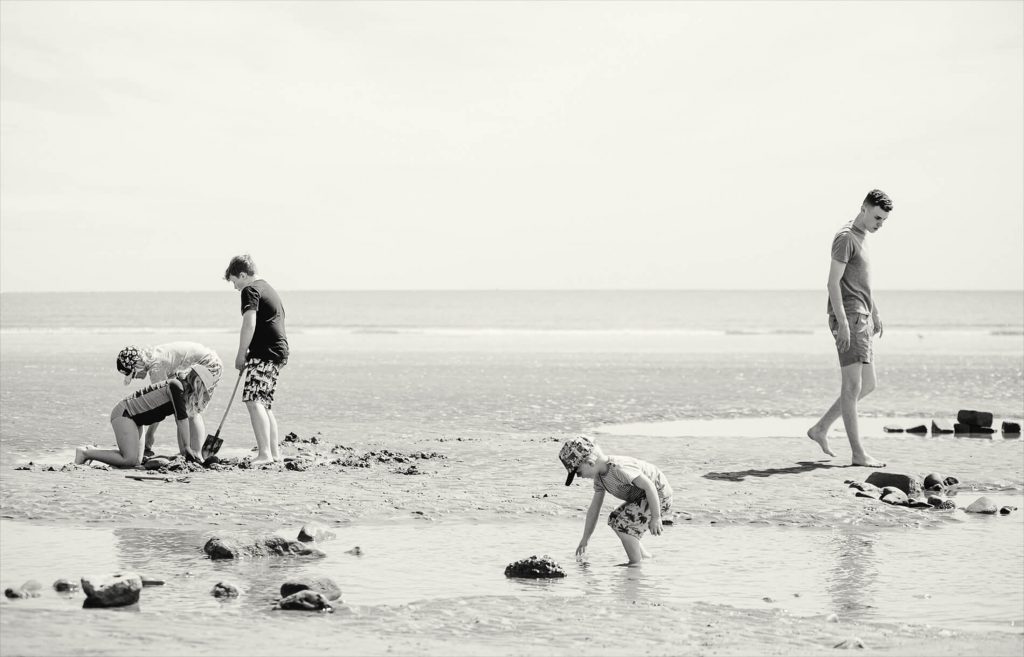 Black and white photography of children playing on the beach at Filey on the Yorkshire coast