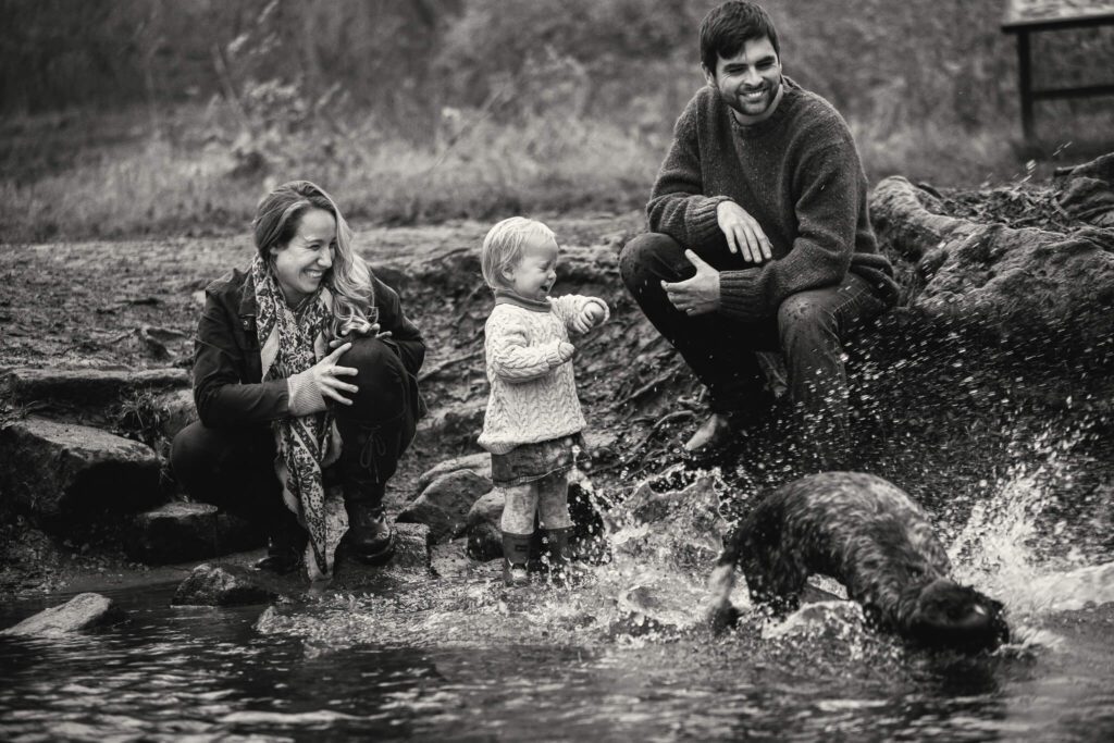 Black and white photo of a family playing in a stream