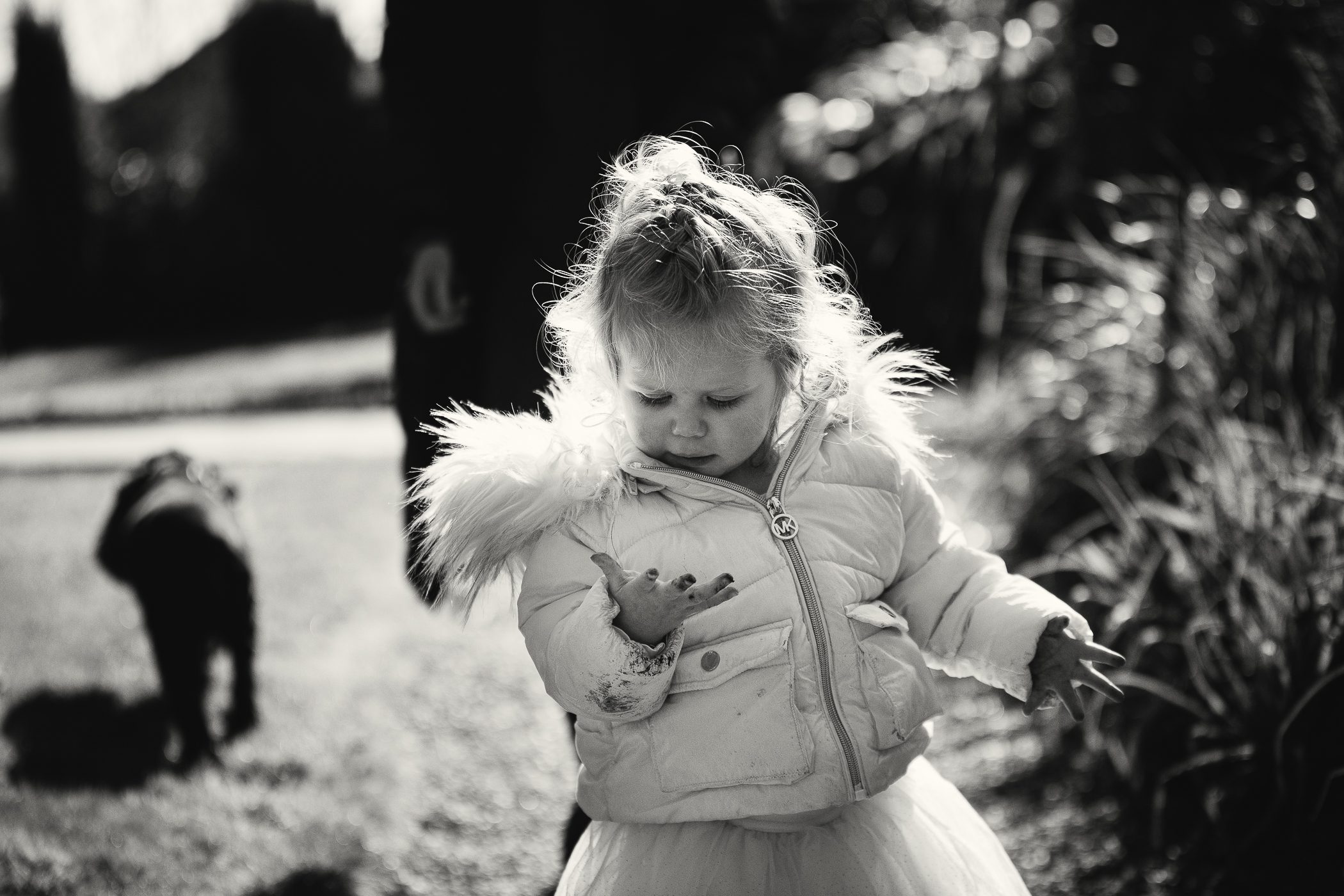 Photo of a young girl looking down at her dirty hands