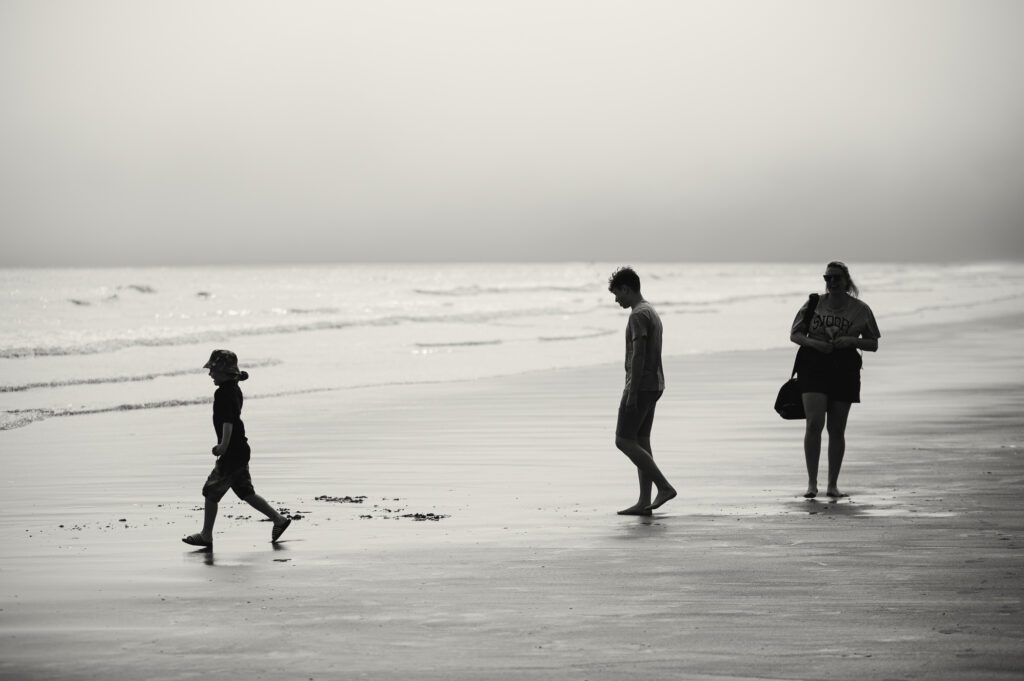 Silhouette of a family shot against an incoming sea fret off the coast of Yorkshire