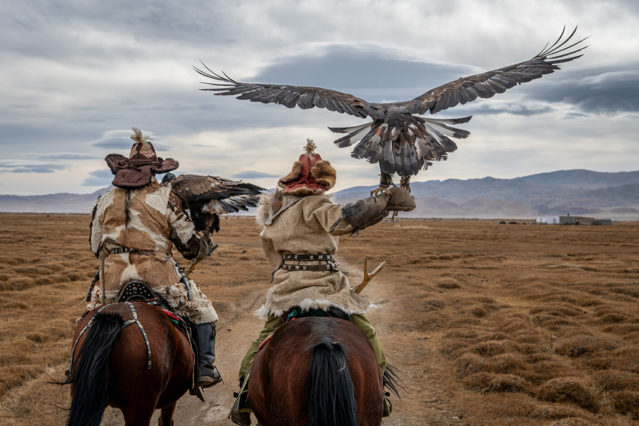 Mongolia, October 2019. Father and son, Alakosh (l.) and twelve-year-old Arkalak, ride with their golden eagles near their family home in the Altai Mountains.