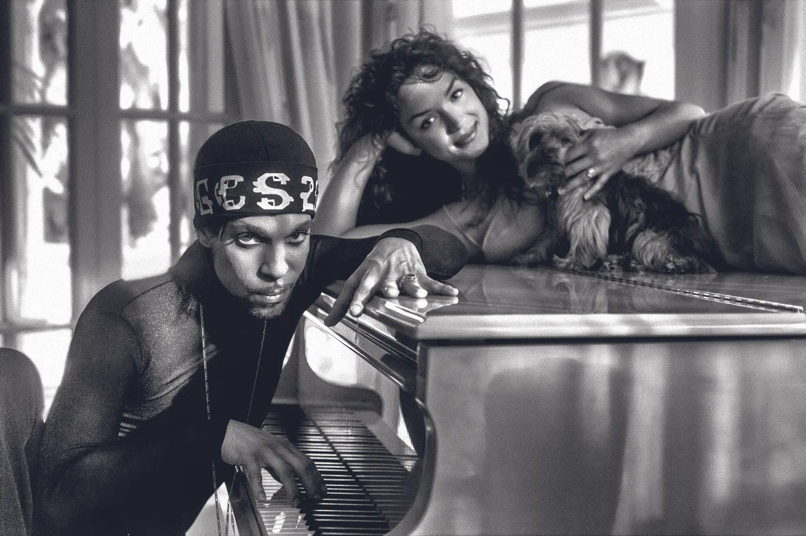 Prince and Mayte at their home in Marbella, Spain. 'Prince and Mayte with one of their dogs, Mia, posing on the piano. Mia was quite the trooper that day. I loved the light coming from all the windows and doors in this shot.' © Steve Parke